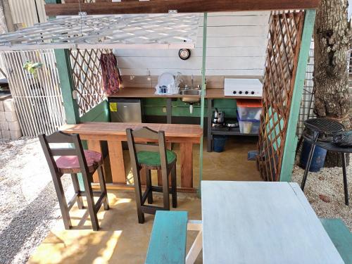 una cocina al aire libre con mesa de madera y sillas en Posada Don Julio en Flores