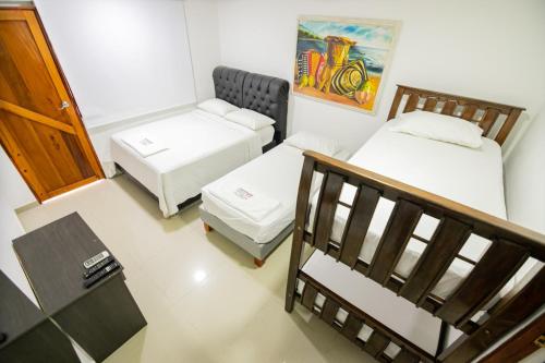 a small room with two beds and a staircase at Hotel La Casona de Getsemani in Cartagena de Indias