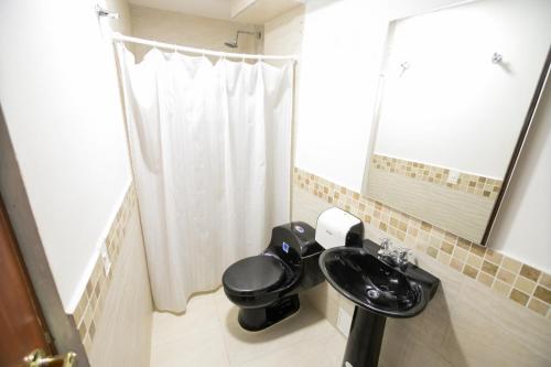 a bathroom with a sink and a toilet and a mirror at Hotel La Casona de Getsemani in Cartagena de Indias