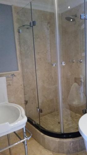 a shower with a glass door next to a sink at Mt Bijoux Preferred Accommodation in Bloubergstrand