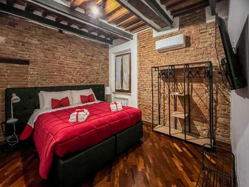a bedroom with a red bed in a brick wall at Zero45 San Martino Apartment in Grosseto