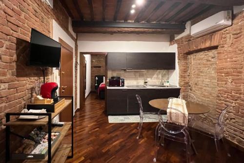 a kitchen with a table and a brick wall at Zero45 San Martino Apartment in Grosseto