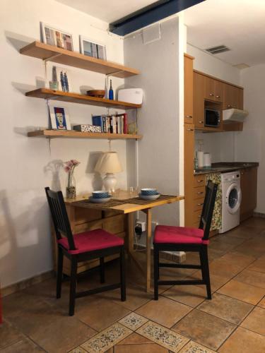 cocina con mesa de madera y 2 sillas en Estudio Casco antiguo Tarragona, en Tarragona
