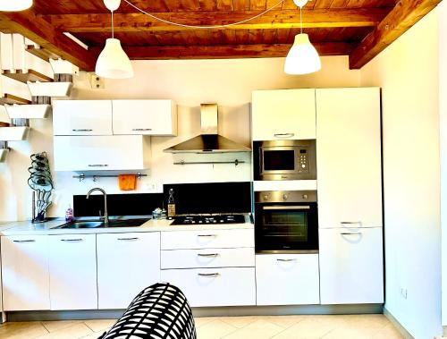 una cocina blanca con armarios y electrodomésticos blancos en GG HOME, en Cosenza