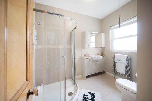 a bathroom with a shower and a sink at 4 bedroom home with Garden, Game room, Parking- Esho Stays in Gloucester