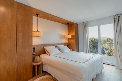 - une chambre avec un lit et une grande fenêtre dans l'établissement Villa Joia, à Saint-Tropez