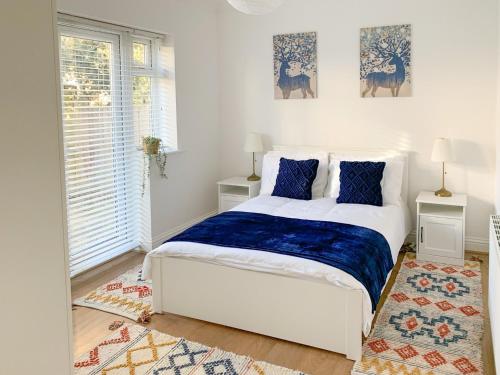 a bedroom with a white bed with blue pillows at Panorama Apartment 1 - Uk40626 in Southbourne