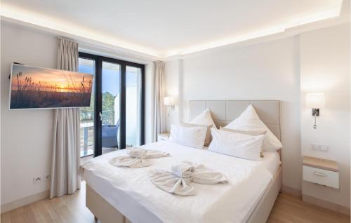 a white bedroom with a large white bed with two bows at Angel in Binz