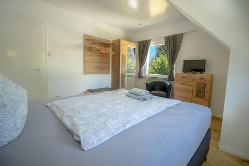 Un dormitorio con una gran cama blanca y una ventana en Am Klosterviertel, en Bad Herrenalb