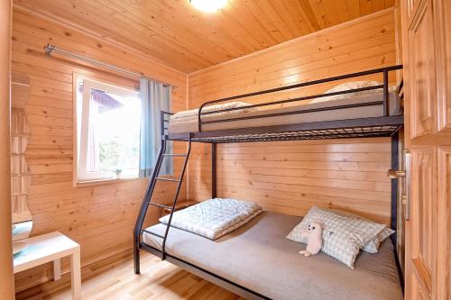 a bedroom with bunk beds in a log cabin at Domki letniskowe Krakowiak in Wicie