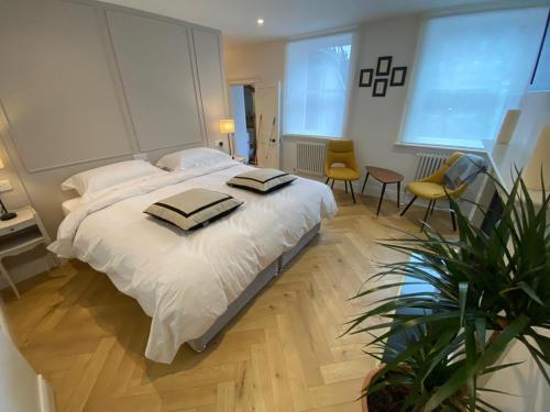 sypialnia z dużym białym łóżkiem z 2 krzesłami w obiekcie Pembroke Guest Suite w Dublinie