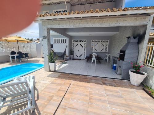 um pátio com uma piscina e uma casa em Casa cinza em Aracaju