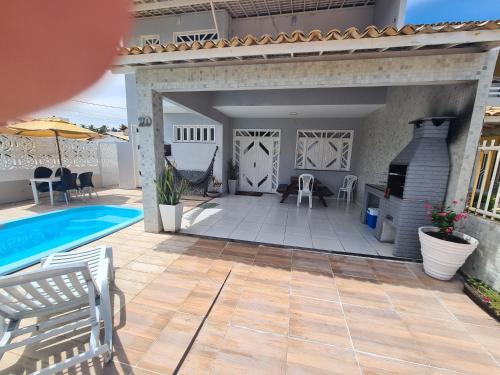 une terrasse avec une piscine et une maison dans l'établissement Casa cinza, à Aracaju