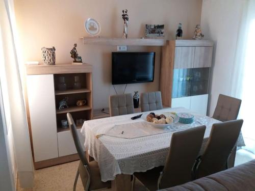 a dining room with a table with chairs and a television at relax apartamento in Son Carrio