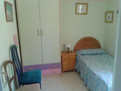 a bedroom with a bed and a cabinet and a chair at relax apartamento in Son Carrio