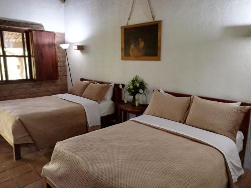 a hotel room with two beds and a window at Hotel Hacienda San Lucas in Copán Ruinas