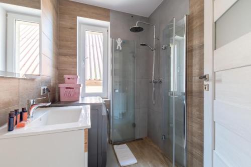 a bathroom with a sink and a shower at Familia Apartament na wzgórzu 3 z sauną i salą zabaw dla dzieci in Gdynia
