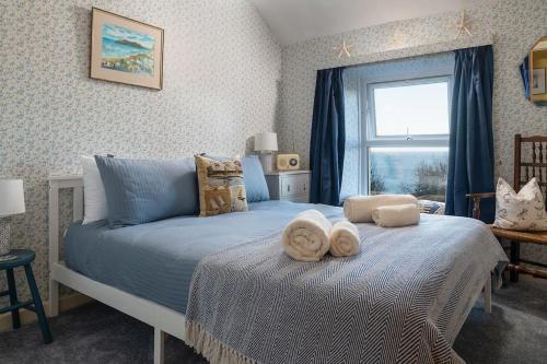 a bedroom with a bed with towels on it at Alma's Cottage at Penmaenmawr in Penmaen-mawr