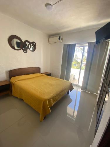 a bedroom with a bed and a large window at hermoso condominio suites las palmas con alberca in Manzanillo