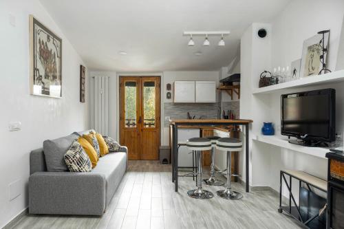 een woonkamer met een bank en een keuken bij Loft Deluxe Magnolia - Ovindoli in Ovindoli