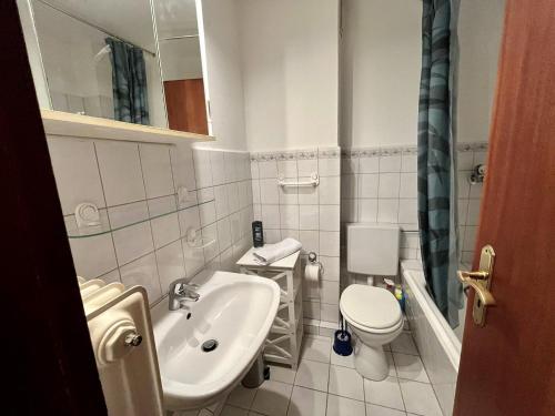 La petite salle de bains est pourvue d'un lavabo et de toilettes. dans l'établissement Apartment mit großer Terrasse, à Neumünster