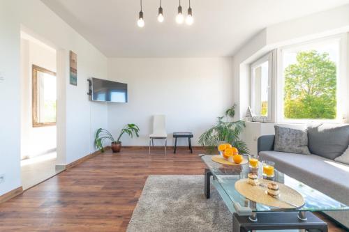 a living room with a couch and a table at Familia Apartament na wzgórzu 2 z sauną i salą zabaw dla dzieci in Gdynia