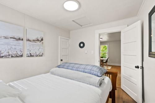 - une chambre blanche avec un lit et un miroir dans l'établissement 2-Bedroom Bungaloo nestled close to Urban Centers, à Vancouver