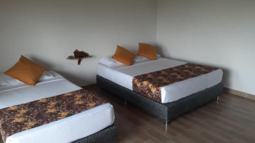 Cette chambre comprend deux lits et un canapé. dans l'établissement Hotel Las Aldeas, à Montenegro