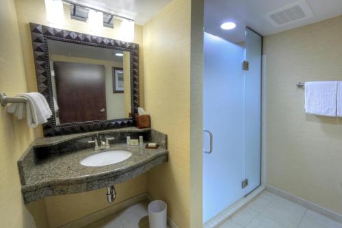 a bathroom with a sink and a mirror and a shower at Courtyard Marriott Lake Placid in Lake Placid