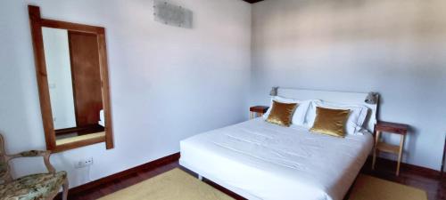 a bedroom with a bed with two pillows and a mirror at Big Fish 1 - Charming Beach Apartment in Praia de Mira