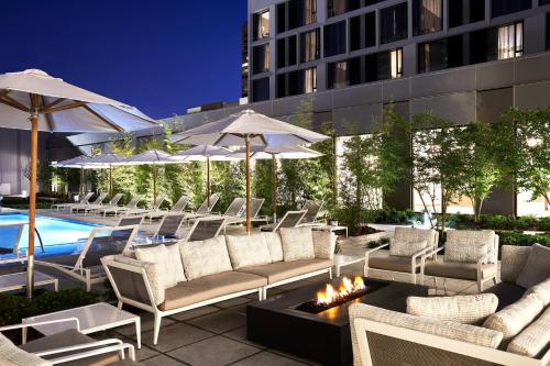 a patio with lounge chairs and a pool with umbrellas at Residence Inn By Marriott Dallas By The Galleria in Dallas