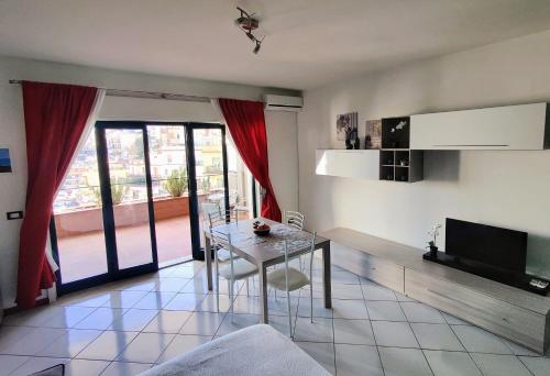 een woonkamer met een tafel en een televisie bij Dolce Casa Taormina in Taormina