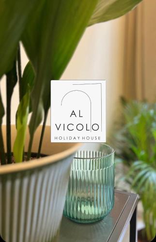 um vaso de vidro sentado numa mesa ao lado de uma planta em Al Vicolo em Terracina