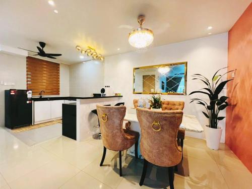 eine Küche mit einem Tisch und Stühlen im Zimmer in der Unterkunft Alaghapoo Service Apartment Near Drawbridge in Kuala Terengganu