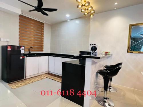 a black and white kitchen with a ceiling fan at Alaghapoo Service Apartment Near Drawbridge in Kuala Terengganu