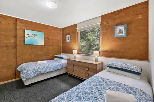 una camera con due letti e una finestra di Split Point Cottages ad Aireys Inlet