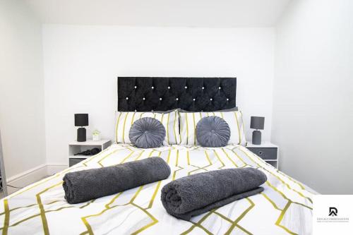 a bedroom with a large bed with two pillows at WEEKLY & MONTHLY STAY - Beautiful 2 Bed House with FREE Parking - Relocation, Business & Group - 5 Guests - By Den Accommodation Short Lets & Serviced Accommodation, Woolwich in Woolwich