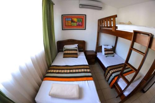 Cette chambre comprend 2 lits superposés et une fenêtre. dans l'établissement Alojamiento en Playa Herradura, à Herradura