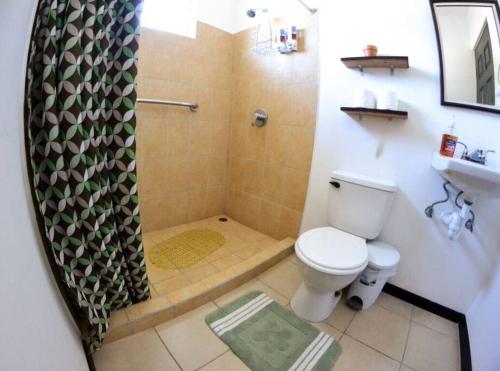a bathroom with a shower with a toilet and a sink at Alojamiento en Playa Herradura in Herradura