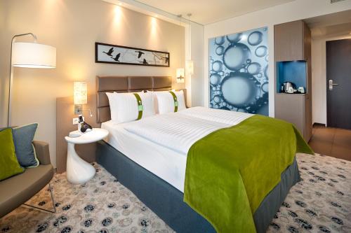 a hotel room with a large bed and a large mirror at Holiday Inn Berlin City East Side, an IHG Hotel in Berlin
