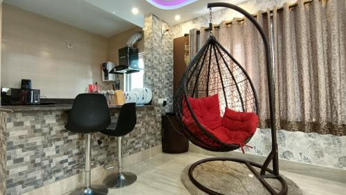 a room with a red hammock in a kitchen at Luxurious studio apartment in Newtown in Thākurdwari