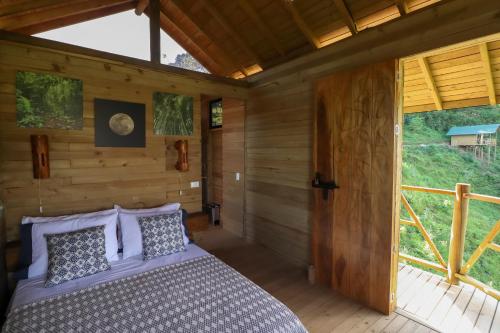 1 dormitorio con 1 cama en una cabaña de madera en Glamping Encanto de Luna, en Fredonia