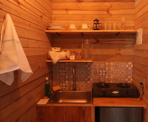 a kitchen with a sink and a stove at Glamping Encanto de Luna in Fredonia