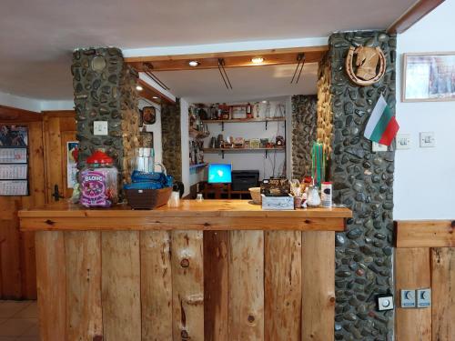 a bar in a room with a stone wall at Къща за гости Бялото Конче in Beli Iskar