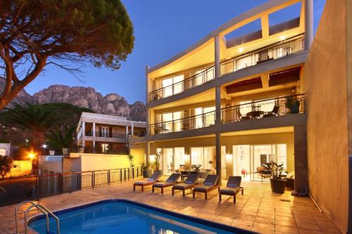 a house with a swimming pool next to a building at Balfour Place Guesthouse in Cape Town