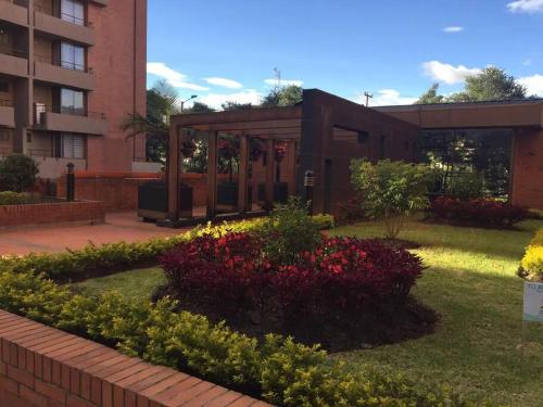 einen Garten mit Blumen vor einem Gebäude in der Unterkunft Paraíso del Salitre II in Bogotá