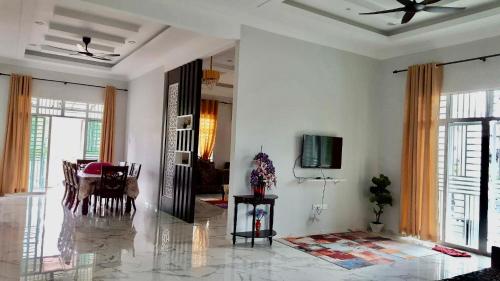 un soggiorno con tavolo e TV di Nazirah Homestay a Pasir Mas