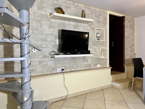 a living room with a flat screen tv on a stone wall at Living Dalia in Carovigno