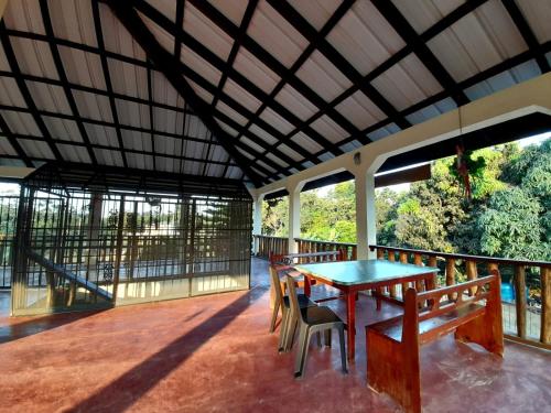 Habitación con balcón con mesa y sillas. en Cabaña Don Tobo Jarabacoa RD, en Jarabacoa