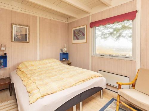 een slaapkamer met een bed, een raam en een stoel bij Holiday home Gilleleje X in Gilleleje